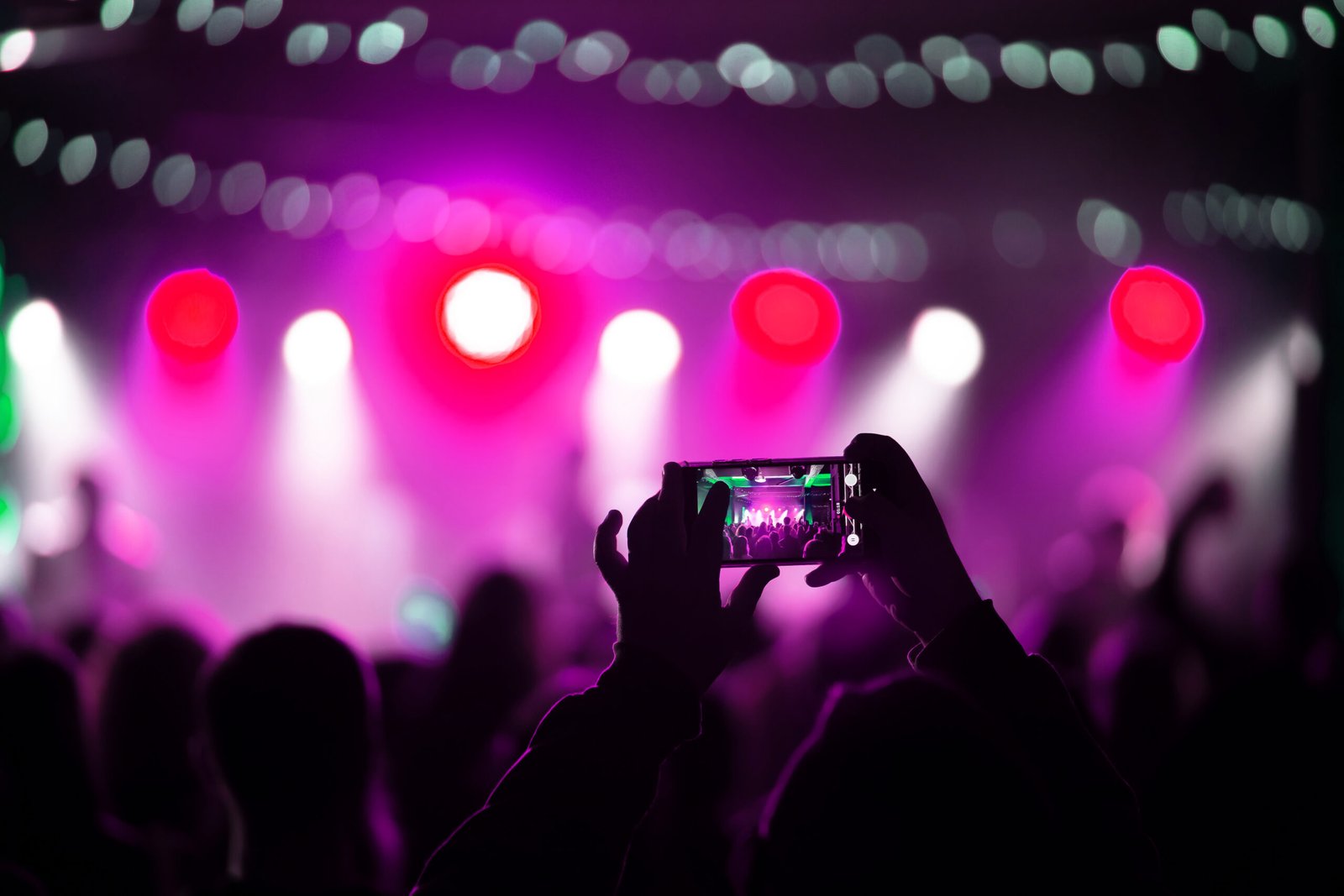 Close up of recording video with smartphone during a concert. Toned picture